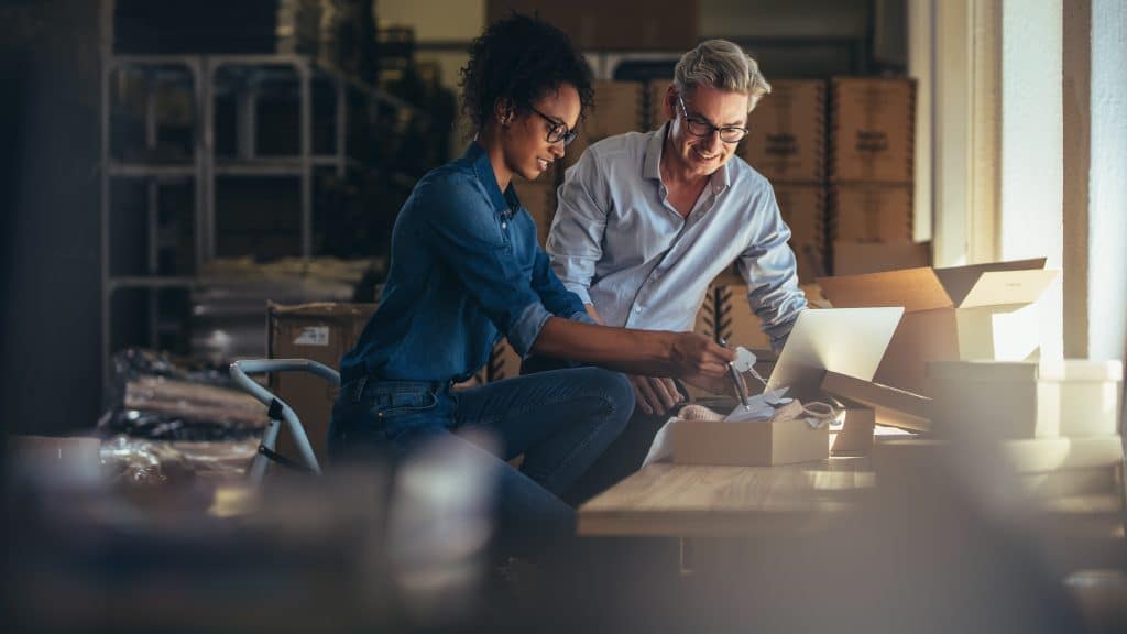 Man and woman packing the products for delivery through customer portal.